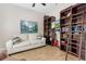 Cozy living room with hardwood floors, a comfortable sofa, and a TV mounted on a bookshelf at 6871 Forkmead Ln, Port Orange, FL 32128