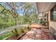 Lovely backyard features a wooden deck overlooking a tranquil waterfront view with mature trees and lush landscaping at 71 Crooked Pine Rd, Port Orange, FL 32128
