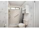 Bathroom showcasing a shower with a grab bar and shelves, and a comfortable toilet in an older style at 71 Crooked Pine Rd, Port Orange, FL 32128