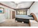 Cozy bedroom featuring a ceiling fan, window views, floral wallpaper and an adjacent bathroom at 71 Crooked Pine Rd, Port Orange, FL 32128