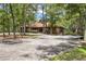 Community clubhouse featuring a circular driveway, lush trees, and American flag at 71 Crooked Pine Rd, Port Orange, FL 32128