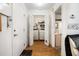 Hallway view to laundry closet with bi-fold doors revealing stacked washer and dryer and shelving for storage at 71 Crooked Pine Rd, Port Orange, FL 32128