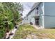 Backyard featuring lush greenery, patio, and balcony views to the upper level at 721 Laurel Bay Cir, New Smyrna Beach, FL 32169