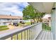 Balcony view featuring well-maintained condos, street view, and partial lake view with a mature tree at 721 Laurel Bay Cir, New Smyrna Beach, FL 32169