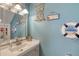 Coastal-themed half bath features a modern vanity, mirror, and decorative elements at 721 Laurel Bay Cir, New Smyrna Beach, FL 32169