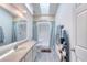 Bright bathroom features a large mirror, neutral countertop, and a convenient walk-in shower at 721 Laurel Bay Cir, New Smyrna Beach, FL 32169