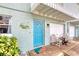 Beautiful front entrance with a bright blue door, charming decor, and outdoor seating at 721 Laurel Bay Cir, New Smyrna Beach, FL 32169