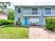 Charming two-story townhome featuring a light blue exterior, balcony, brick driveway and well-manicured lawn at 721 Laurel Bay Cir, New Smyrna Beach, FL 32169