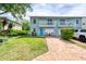 Charming townhome with a light blue facade, a welcoming brick driveway, and manicured landscaping at 721 Laurel Bay Cir, New Smyrna Beach, FL 32169