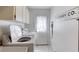Clean laundry room with white cabinetry, washer, and a charming 