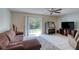 Bright living space features a sofa, entertainment center, and sliding glass doors to backyard at 721 Laurel Bay Cir, New Smyrna Beach, FL 32169