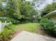Landscaped backyard with grass, a small concrete patio, and privacy fence at 733 E Ohio Ave, Deland, FL 32724