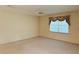 Spacious bedroom with neutral carpet, ceiling fan, and a large window dressed with floral valance at 733 E Ohio Ave, Deland, FL 32724