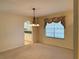 Dining area featuring a chandelier, window, and carpet with an open archway leading to the kitchen at 733 E Ohio Ave, Deland, FL 32724
