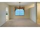 Dining area featuring a window, chandelier, neutral carpet, and open access to the kitchen at 733 E Ohio Ave, Deland, FL 32724