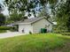 Exterior of the home with two-car garage, lawn, and green waste bins at 733 E Ohio Ave, Deland, FL 32724