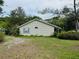 Exterior view of home with siding, a simple landscape, and small, arched window at 733 E Ohio Ave, Deland, FL 32724