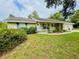 Charming single-story home with light yellow siding, blue shutters, covered porch, and well-maintained lawn at 733 E Ohio Ave, Deland, FL 32724