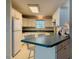 Functional kitchen with white cabinets, green countertops, breakfast bar, and classic appliances at 733 E Ohio Ave, Deland, FL 32724