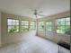 Bright sunroom with large windows, tile flooring, ceiling fan, and a door leading to the backyard at 733 E Ohio Ave, Deland, FL 32724