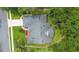 Aerial view of the home with a driveway, lush greenery, and a well-maintained roof at 802 Royal Oak Ct, Deland, FL 32724