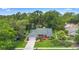 Aerial shot of the red brick home featuring a lush green lawn and mature trees surrounding the property at 802 Royal Oak Ct, Deland, FL 32724