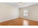 Empty bedroom with hardwood floors, a modern chandelier, and a large window for natural light at 802 Royal Oak Ct, Deland, FL 32724