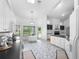 Open kitchen and dining area with island, white cabinets, and tiled floors at 802 Royal Oak Ct, Deland, FL 32724