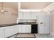Bright kitchen features white cabinetry, black appliances, and modern finishes at 802 Royal Oak Ct, Deland, FL 32724