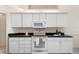 The bright kitchen is equipped with white cabinets and appliances at 802 Royal Oak Ct, Deland, FL 32724