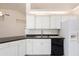 Bright kitchen features white cabinetry, black appliances, and modern finishes at 802 Royal Oak Ct, Deland, FL 32724