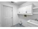 Bright laundry room with white cabinets, sink, and blue tiled floor at 802 Royal Oak Ct, Deland, FL 32724