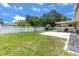 Well-maintained backyard with a playset, a covered patio with seating, and a white privacy fence at 833 Lucerne Cir, Ormond Beach, FL 32174