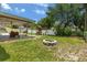 Backyard with a covered patio, playset, fire pit, and lush lawn at 833 Lucerne Cir, Ormond Beach, FL 32174