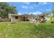 Expansive backyard featuring a covered patio, playset, and a fire pit at 833 Lucerne Cir, Ormond Beach, FL 32174