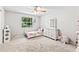 Bright bedroom with a ceiling fan, gray carpet, and a large window offering natural light at 833 Lucerne Cir, Ormond Beach, FL 32174