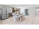 Spacious dining room featuring tile floors, a large rustic table with bench seating, and stainless steel refrigerator at 833 Lucerne Cir, Ormond Beach, FL 32174