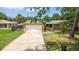 Charming home featuring a large front yard, mature trees, neutral paint, a large driveway, and an attached garage at 833 Lucerne Cir, Ormond Beach, FL 32174