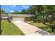 Charming home featuring a large front yard, mature trees, neutral paint, a large driveway, and an attached garage at 833 Lucerne Cir, Ormond Beach, FL 32174