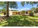 Charming home exterior with a lush green lawn, mature trees, and inviting curb appeal at 833 Lucerne Cir, Ormond Beach, FL 32174