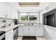 Bright kitchen features white cabinets, stainless steel appliances, and a view to the backyard at 833 Lucerne Cir, Ormond Beach, FL 32174
