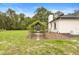 Expansive backyard featuring a stone pathway leading to a covered patio and well-maintained lawn at 940 Glenwood Rd, Deland, FL 32720