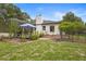 Backyard view of the house and a screened-in patio with lush landscaping and open lawn at 940 Glenwood Rd, Deland, FL 32720