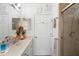 Bright bathroom features a single sink vanity, shower, and decorative fixtures with light tile flooring at 940 Glenwood Rd, Deland, FL 32720