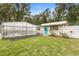 Charming exterior of a small house with a blue door and a greenhouse attached on the side at 940 Glenwood Rd, Deland, FL 32720