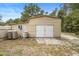 View of a backyard barn featuring metal siding, white doors, and two water tanks at 940 Glenwood Rd, Deland, FL 32720