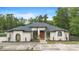 Stunning single-story stucco home featuring a symmetrical design, a concrete driveway, and manicured landscaping at 940 Glenwood Rd, Deland, FL 32720