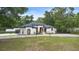 Beautifully landscaped front yard showcasing a modern, stucco home with arched windows and a circular driveway at 940 Glenwood Rd, Deland, FL 32720