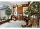 Unique living room showcasing wood paneling, a large arched window, and eclectic décor at 940 Glenwood Rd, Deland, FL 32720