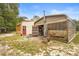 The exterior of a metal outbuilding featuring both metal and wood, with a red door, and set in a grassy yard at 940 Glenwood Rd, Deland, FL 32720